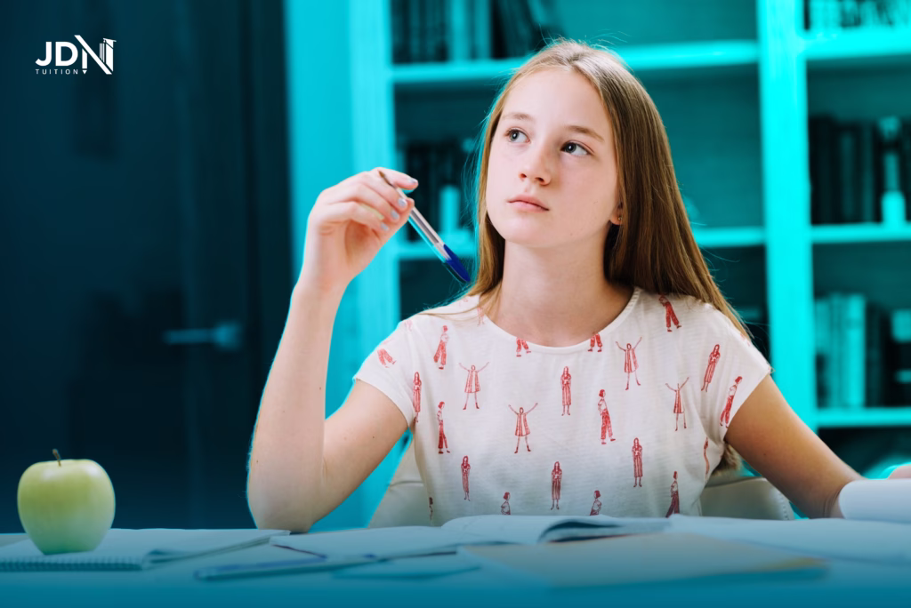 A student sits at a desk with a pencil and paper completing the Writing Test, deep in thought.
